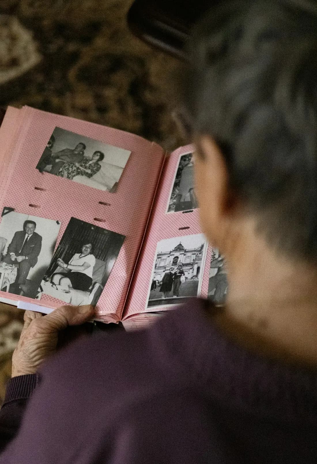 Una persona mayor mira un álbum de fotos familiares